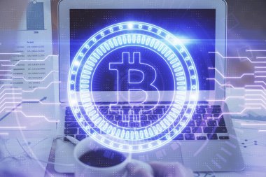 Blockchain temalı holograma ve bilgisayar arkaplanlı masaya çift pozlama. Bitcoin şifreleme para birimi kavramı.