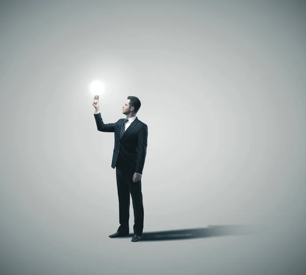 Businessman holding glowing lamp — Stock Photo, Image