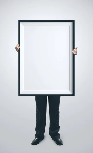Empresario sosteniendo cartel en blanco — Foto de Stock