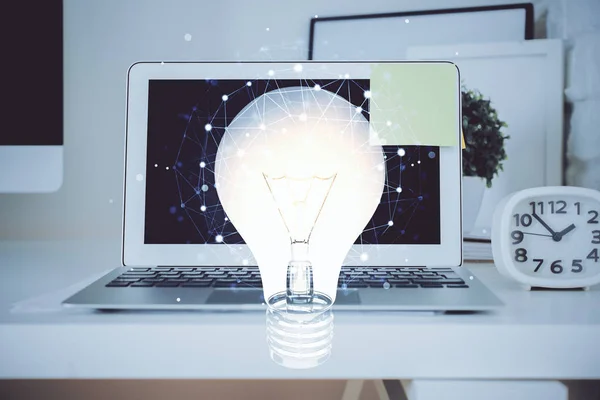 Ordenador en el escritorio en la oficina con el holograma icono de la bombilla. Exposición múltiple. Concepto de idea. —  Fotos de Stock