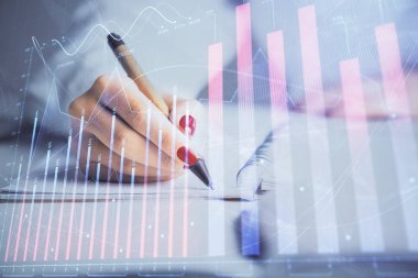Forex grafik hologramı ile not lar yapan kadın ellerinin çift pozlama. Konsept borsa analizi.
