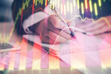 Bir kadın eller Not defteri hisse senedi piyasası hakkında bilgi yazma. Ön Forex grafik hologramlar. Araştırma kavramı. Çoklu pozlama