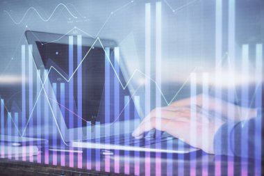 Arka planda dizüstü bilgisayar üzerinde çalışan adam ile borsa grafiği çift pozlama. Finansal analiz kavramı.