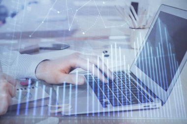 Arka planda dizüstü bilgisayar üzerinde çalışan adam ile borsa grafiği çift pozlama. Finansal analiz kavramı.