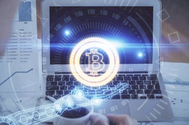 Blockchain temalı holograma ve bilgisayar arkaplanlı masaya çift pozlama. Bitcoin şifreleme para birimi kavramı.