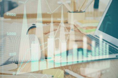 Arka planda dizüstü bilgisayar üzerinde çalışan adam ile borsa grafiği çoklu pozlama. Finansal analiz kavramı.