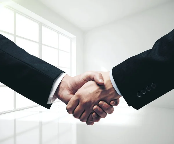 Businessmen shaking hands in modern interior. — Stock Photo, Image