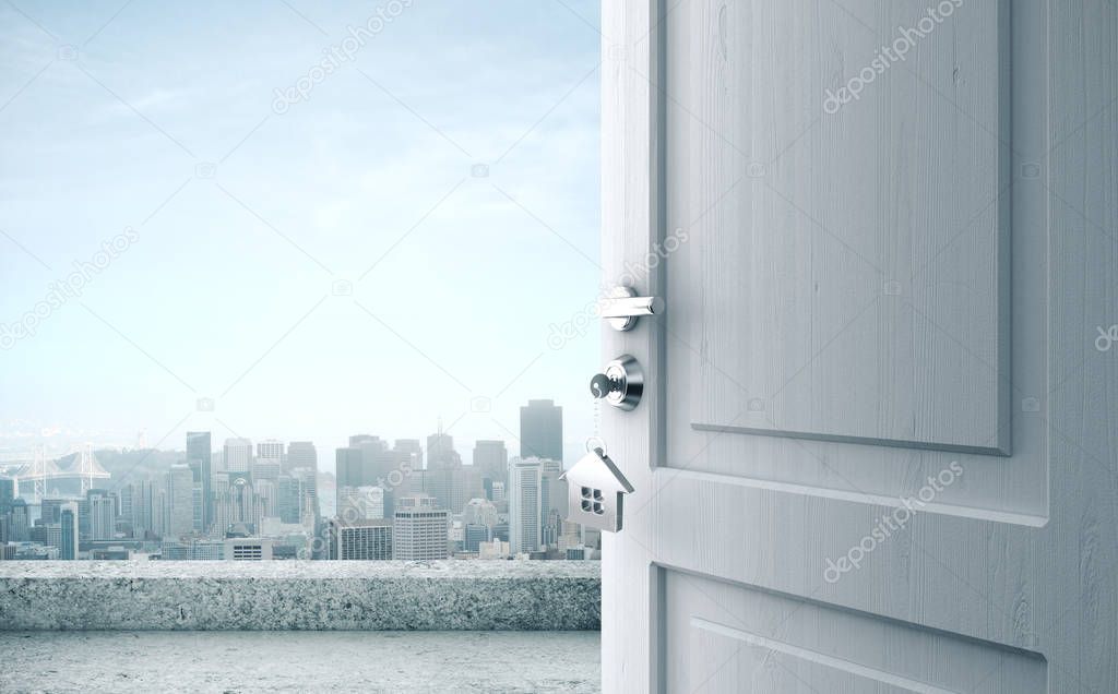 Opened door with key in lock and city view.