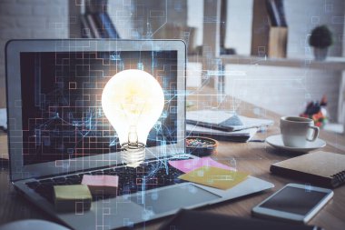 Bilgisayar ofisinde ampul simgesi hologramıyla birlikte. Çoklu maruz kalma. Fikir kavramı.