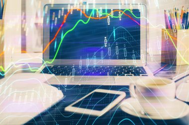 Finansal pazar grafiği hologramı ve kişisel bilgisayar arka planda. Çoklu maruz kalma. Önx kavramı.