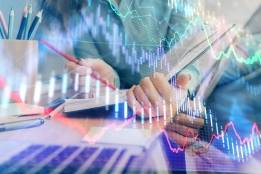 Bir kadın eller Not defteri hisse senedi piyasası hakkında bilgi yazma. Ön Forex grafik hologramlar. Araştırma kavramı. Çoklu pozlama