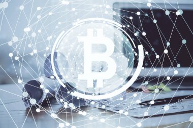 Engelleme zinciri ve kripto ekonomi temalı hologram ve bilgisayar geçmişi olan bir masa. Bitcoin kripto para kavramı.