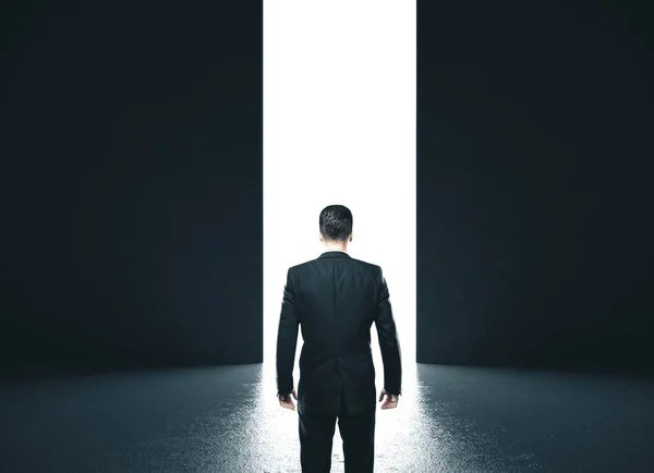 Businessman in concrete room with open door — Stok fotoğraf