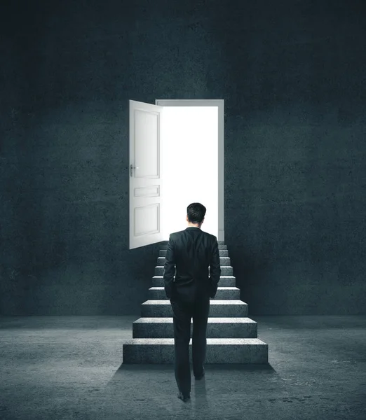 Empresário em sala de concreto andando para abrir a porta — Fotografia de Stock