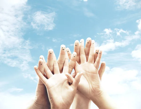 Grupp av finger smileys på blå himmel bakgrund. — Stockfoto