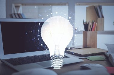 Bilgisayar ofisinde ampul simgesi hologramıyla birlikte. Çoklu maruz kalma. Fikir kavramı.