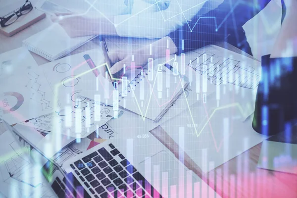 A woman hands writing information about stock market in notepad. Forex chart holograms in front. Concept of research. Double exposure — Stock Photo, Image