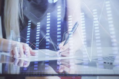 Bir kadın eller Not defteri hisse senedi piyasası hakkında bilgi yazma. Ön Forex grafik hologramlar. Araştırma konsepti.