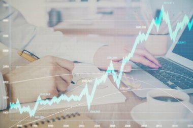 Arka planda dizüstü bilgisayar üzerinde çalışan adam ile borsa grafiği çoklu pozlama. Finansal analiz kavramı.