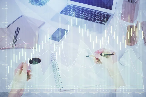 Hands writing information about stock market in notepad. Forex chart holograms in front. Concept of research. Multi exposure