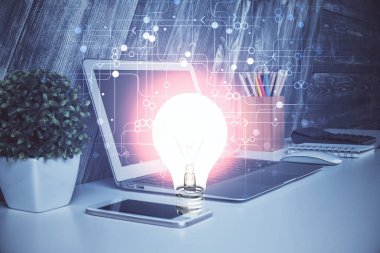 Bilgisayar ofisinde ampul simgesi hologramıyla birlikte. Çoklu maruz kalma. Fikir kavramı.