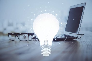 Bilgisayar ofisinde ampul simgesi hologramıyla birlikte. Çoklu maruz kalma. Fikir kavramı.