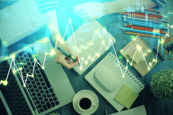 Financial chart drawn over hands taking notes background. Concept of research. Double exposure