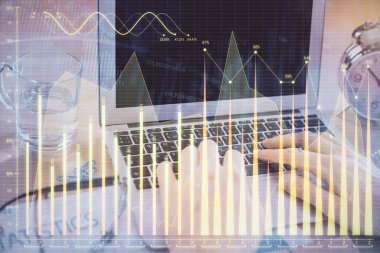 Arka planda bilgisayar üzerinde çalışan bir adamla birlikte çok sayıda piyasa haritasına maruz kaldık. Mali analiz kavramı.