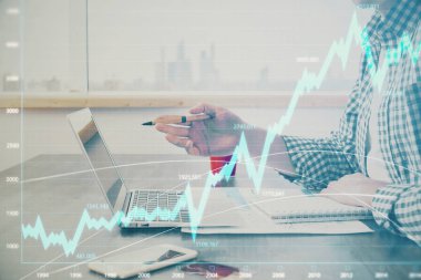 Arka planda bilgisayar üzerinde çalışan adam ile borsa grafiği çoklu pozlama. Finansal analiz kavramı.