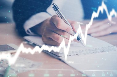 Bir kadın eller Not defteri hisse senedi piyasası hakkında bilgi yazma. Ön Forex grafik hologramlar. Araştırma kavramı. Çoklu pozlama