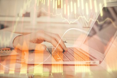 Arka planda dizüstü bilgisayar üzerinde çalışan adam ile borsa grafiği çift pozlama. Finansal analiz kavramı.