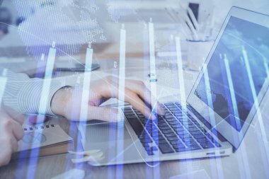 Arka planda dizüstü bilgisayar üzerinde çalışan adam ile borsa grafiği çift pozlama. Finansal analiz kavramı.