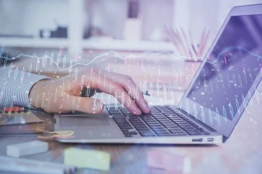 Arka planda dizüstü bilgisayar üzerinde çalışan adam ile borsa grafiği çift pozlama. Finansal analiz kavramı.