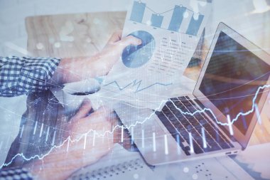 Arka planda ofiste bilgisayarda işadamı yazarak stok grafik çift pozlama. Zor iş kavramı.