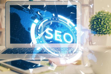 Bilgisayar ve seo çizim hologramı olan bir masanın çifte görüntüsü. Arama optimizasyon kavramı.