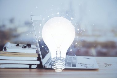 Bilgisayar ofisinde ampul simgesi hologramıyla birlikte. Çoklu maruz kalma. Fikir kavramı.