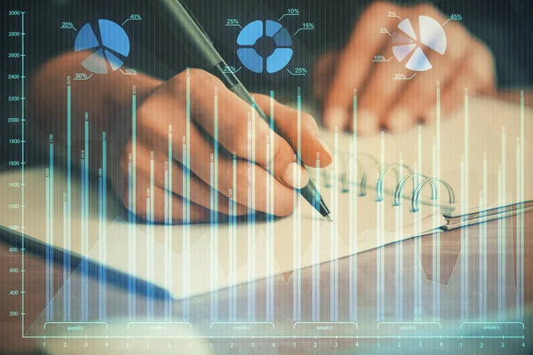 Forex graph on hand taking notes background. Concept of research. Double exposure