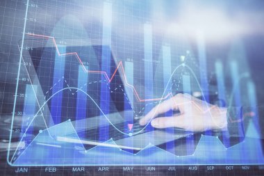 Arka planda dizüstü bilgisayar üzerinde çalışan adam ile borsa grafiği çift pozlama. Finansal analiz kavramı.