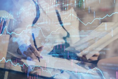 Bir kadın eller Not defteri hisse senedi piyasası hakkında bilgi yazma. Ön Forex grafik hologramlar. Araştırma konsepti.
