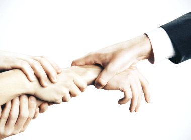 Beyaz bir arka planda el ele tutuşmak. İş ve takım çalışması kavramı.