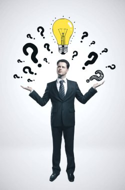 Kafasına soru işareti ve ampul çizen bir iş adamı. İş karmaşası konsepti