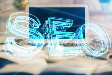 Bilgisayar ve seo çizim hologramı olan bir masanın çifte görüntüsü. Arama optimizasyon kavramı.