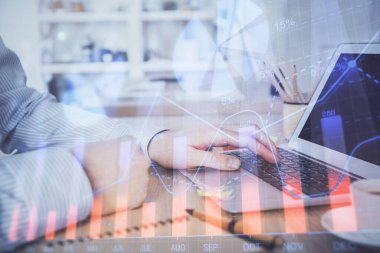 Arka planda bilgisayar üzerinde çalışan adam ile borsa grafiği çoklu pozlama. Finansal analiz kavramı.