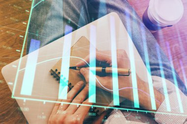 Borsa grafiği ile not defterine yazan ellerin çift pozlama.