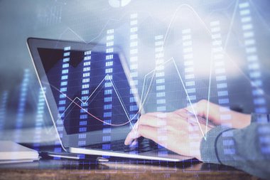 Arka planda dizüstü bilgisayar üzerinde çalışan adam ile borsa grafiği çift pozlama. Finansal analiz kavramı.