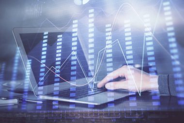 Arka planda dizüstü bilgisayar üzerinde çalışan adam ile borsa grafiği çift pozlama. Finansal analiz kavramı.