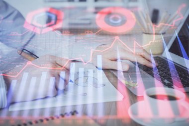 Arka planda dizüstü bilgisayar üzerinde çalışan adam ile borsa grafiği çoklu pozlama. Finansal analiz kavramı.