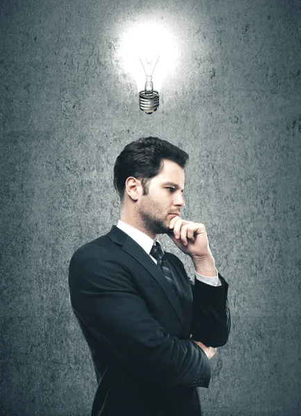 ビジネスマンは頭の上に光るランプを考えている 成功とスタートアップのコンセプト — ストック写真