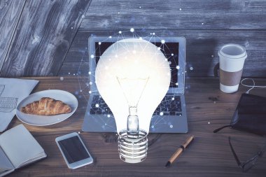 Bilgisayar ofisinde ampul simgesi hologramıyla birlikte. Çoklu maruz kalma. Fikir kavramı.