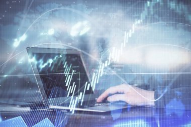 Arka planda dizüstü bilgisayar üzerinde çalışan adam ile borsa grafiği çift pozlama. Finansal analiz kavramı.